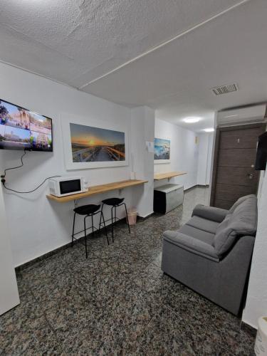 阿利坎特Old Center Inn Alicante的客厅配有沙发和墙上的电视