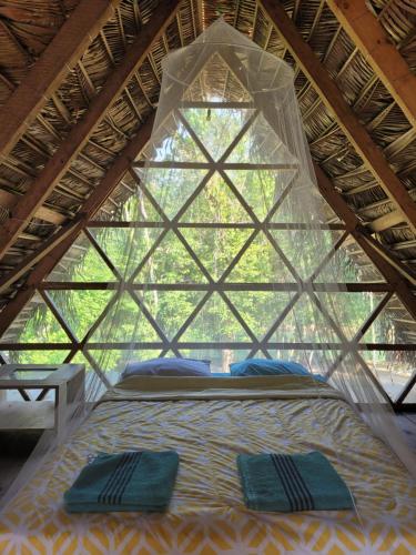 兰金Pachamaya River Hostel的帐篷内的一张床位,上面有两个枕头