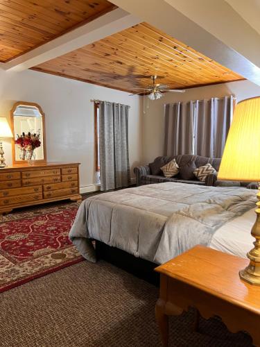 奥斯威戈Oswego Inn的一间卧室设有一张大床和木制天花板
