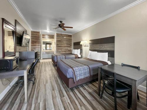 克洛维斯Rodeo Lodge的酒店客房配有两张床和一张书桌