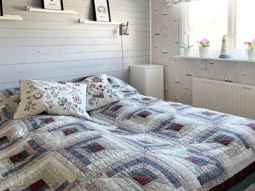 卢恩斯基尔Holiday home LJUNGSKILE VI的卧室内的一张带被子和枕头的床