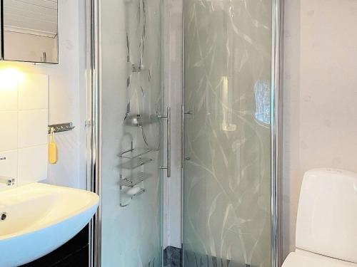 卢恩斯基尔Holiday home LJUNGSKILE VI的带淋浴和白色盥洗盆的浴室