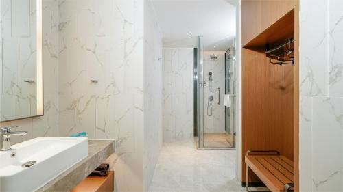 沧州沧州高新智选假日酒店的白色的浴室设有水槽和淋浴。