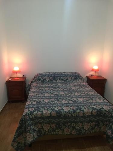 菲安巴拉Cabaña La Angostura的一间卧室配有一张床,两盏台灯放在两张桌子上