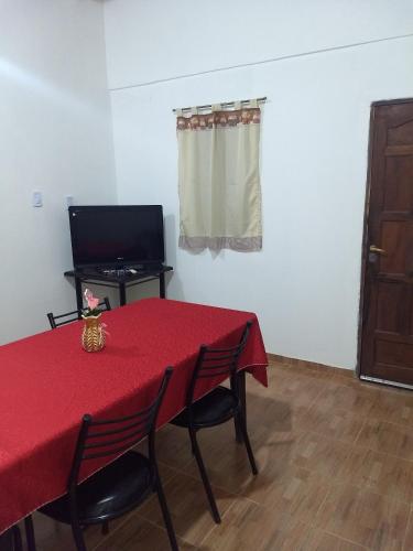 菲安巴拉Cabaña La Angostura的配有红色桌子、椅子和电视的房间