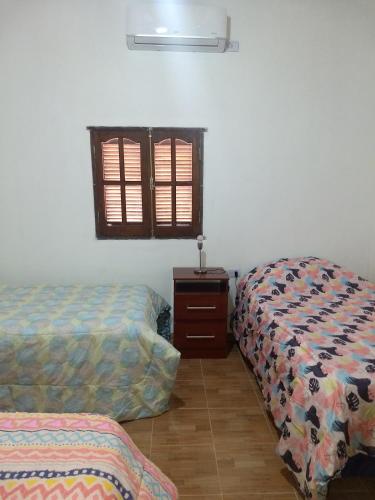 菲安巴拉Cabaña La Angostura的客房设有两张床、梳妆台和窗户。