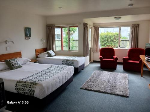 塔卡卡Anatoki Lodge Motel的酒店客房,配有两张床和两把椅子