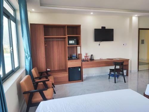 昆岛Hoàng Anh Côn Đảo Hotel的客房设有1张床、1张办公桌和1台电视。