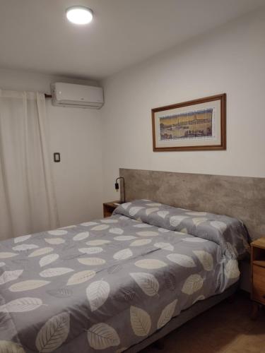 里奥夸尔托Departamento amoblado Rio Cuarto的卧室配有一张带灰色和白色床单的床。