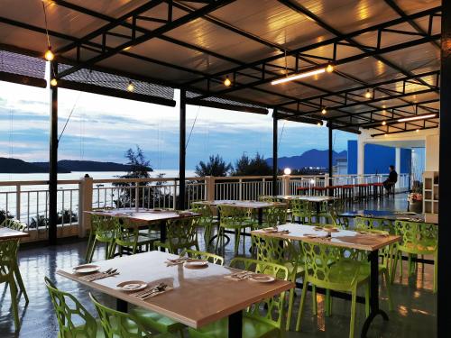 珍南海滩Langkapuri Resort Langkawi的一间设有桌椅并享有水景的餐厅