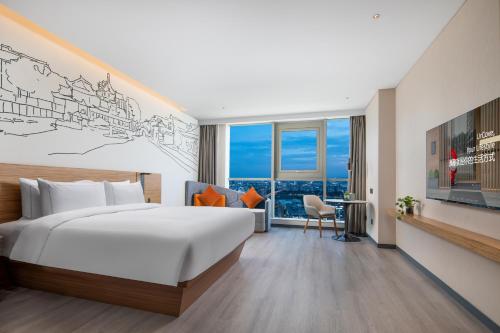 南京南京南站逸扉酒店的酒店客房设有一张大床和一张书桌。