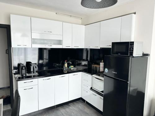 鲁塞Budget Luxury Apartment - Absolutely New Building!的厨房配有白色橱柜和黑色冰箱。