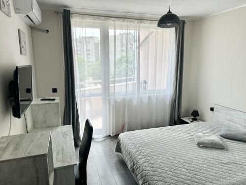 鲁塞Budget Luxury Apartment - Absolutely New Building!的一间卧室设有一张床和一个大窗户
