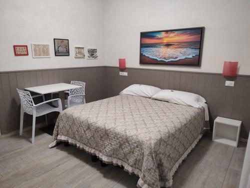 蒂勒尼亚欧罗酒店的一间卧室配有一张床、一张桌子和一张书桌