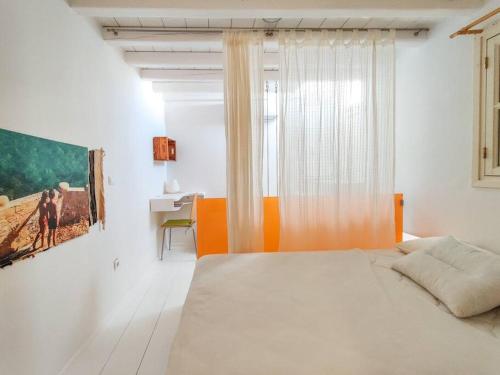 米克诺斯城The Sunday House in the heart of Mykonos Town的白色的卧室设有床和窗户