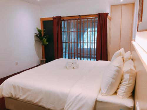马六甲Domo Japanese Style Bedroom的卧室配有一张白色床,上面有两只白色的弓