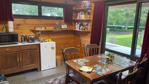 WaltonFantail Garden的厨房配有桌子和白色冰箱。