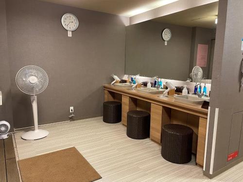 津市多美迎津酒店的一间带水槽和镜子及风扇的浴室