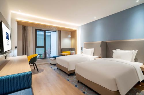 济南济南临空智选假日酒店的酒店客房配有两张床和一张书桌