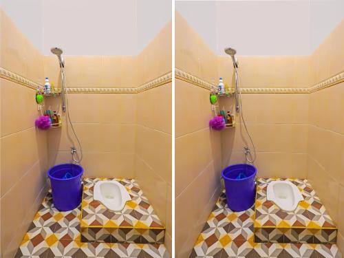 名古屋SPOT ON 92538 Joyoakis Homestay Syariah的浴室设有2个卫生间和2个水桶