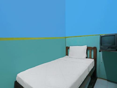 名古屋SPOT ON 92538 Joyoakis Homestay Syariah的一间带床和电视的小卧室
