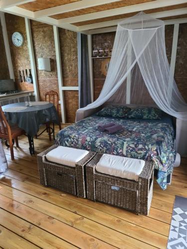 圣罗斯Eden des laves的一间卧室配有一张带天蓬和桌子的床