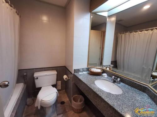 卡农卡农金色海滩酒店的一间带卫生间、水槽和镜子的浴室