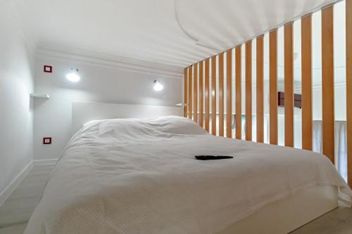 萨格勒布Green Gallery on a Main Square的卧室配有白色的床和木制床头板