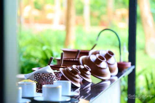 库鲁内格勒Kakulanda Resort的桌子上放有杯子和巧克力甜点
