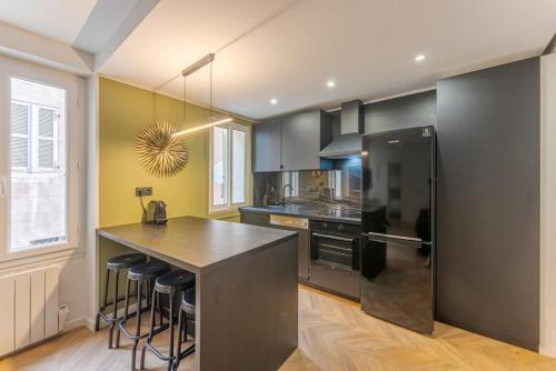 马赛Chez Antho T4 - appart T4 moderne en plein cœur du Panier的厨房配有黑色冰箱和台面