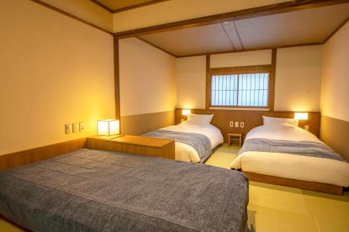 那须盐原市Shionoyu Onsen Rengetsu的一间设有两张床和两盏灯的房间