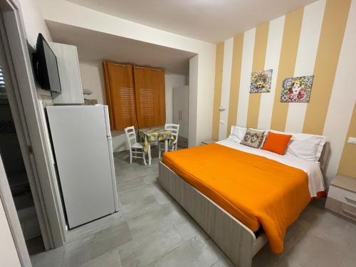 阿格里真托Le Camere Del Villaggio的一间卧室配有一张带橙色毯子的床