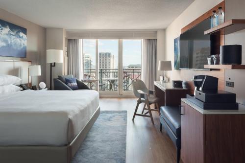坦帕Tampa Marriott Water Street的酒店客房设有一张床、一张书桌和一个阳台。