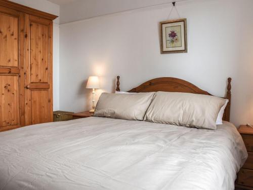 西默西Sunnyside的卧室配有一张白色大床和木制床头板