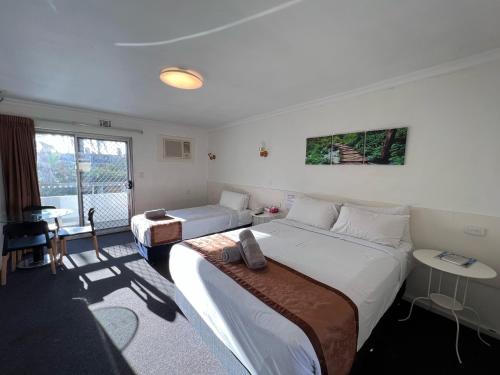 珀斯Econo Lodge Rivervale的酒店客房设有两张床和窗户。