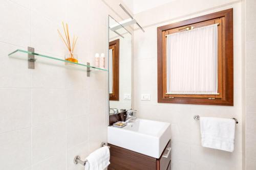 威尼斯卡佛斯克罗公寓的白色的浴室设有水槽和镜子