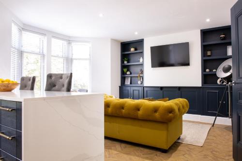卡迪夫Designer Cardiff Apartments的客厅设有黄色沙发和电视