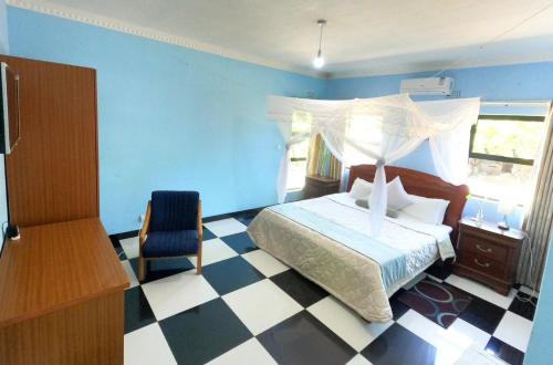 SengaMain Stream Beach Villa的一间卧室,卧室内配有一张床和一把椅子