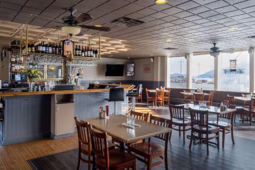 朱诺Ramada by Wyndham Juneau的一间带桌椅的餐厅和一间酒吧