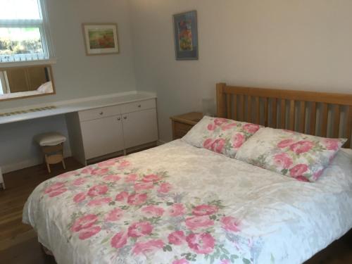 邓韦根Painter's House的一间卧室,床上有粉红色的鲜花