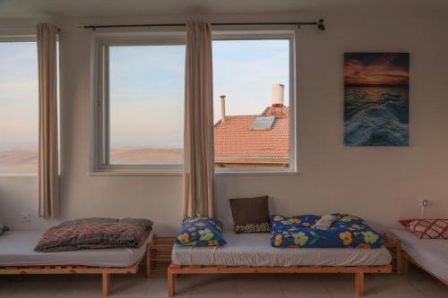 阿拉德רוג'ום גסטהאוס Rujum的客房设有两张床和大窗户。