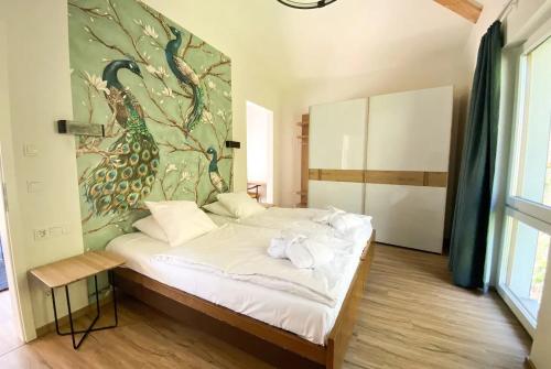 格伦德霍夫Appart-Hotel Ernz Noire的卧室配有一张床铺,墙上挂有孔雀画