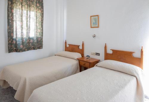 卡沃内拉斯Pensión Las Palmas的客房设有两张床和窗户。