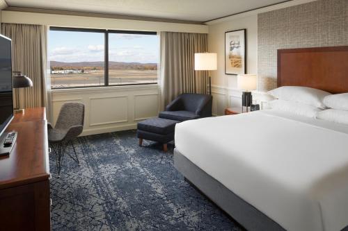 温莎洛克斯哈特福德布拉德利机场喜来登酒店的酒店的客房 - 带一张床、椅子和窗户