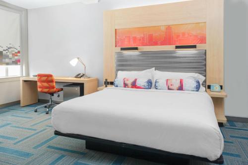 埃尔帕索Aloft El Paso Downtown的酒店客房配有一张床、一张书桌和一张四柱床