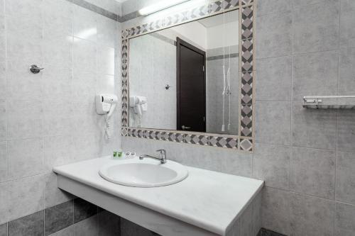 波罗斯Hotel Pavlou的白色的浴室设有水槽和镜子