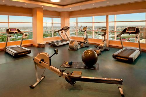 阿特劳Atyrau Executive Apartments的一个带跑步机和椭圆机的健身房,位于一栋带窗户的建筑内
