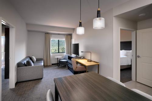 塞多纳Residence Inn by Marriott Sedona的一间带桌子的客厅和一间卧室