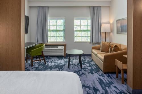 摩根顿Fairfield Inn & Suites Morganton Historic Downtown的酒店客房配有一张床、一张沙发和一张书桌。