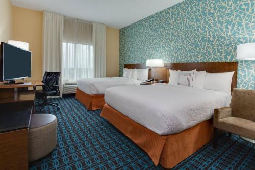 彭布罗克派恩斯劳德代尔堡彭布罗克派恩斯费尔菲尔德客栈套房酒店的酒店客房设有两张床和电视。